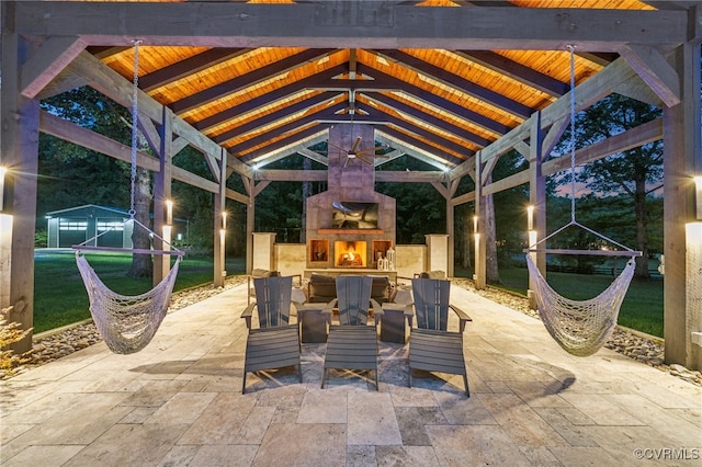 view of patio with a shed, a gazebo, and exterior fireplace