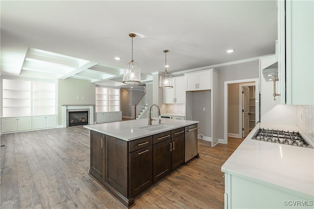 kitchen featuring sink, white cabinetry, hanging light fixtures, dark brown cabinets, and an island with sink