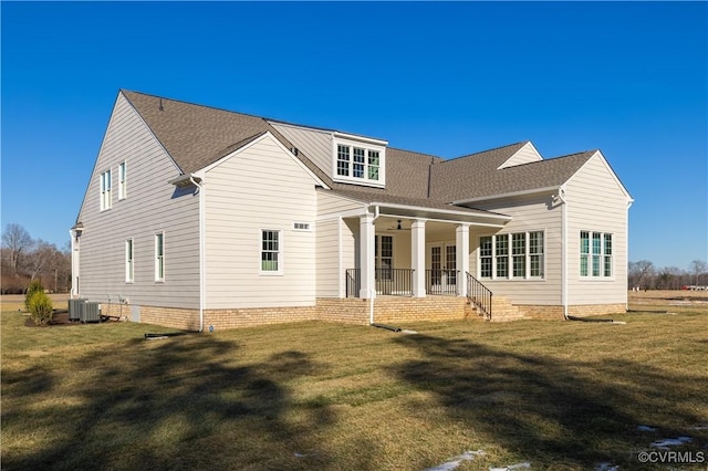 rear view of property featuring central AC unit and a lawn