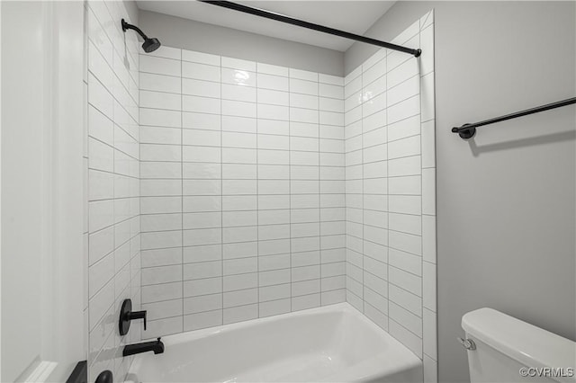 bathroom with toilet and tiled shower / bath