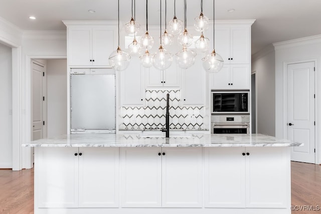 kitchen with light stone counters, a large island with sink, and stainless steel oven