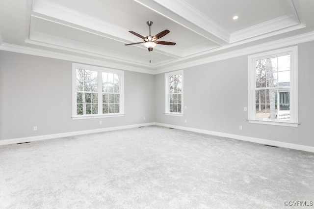 carpeted empty room with a healthy amount of sunlight, crown molding, and ceiling fan