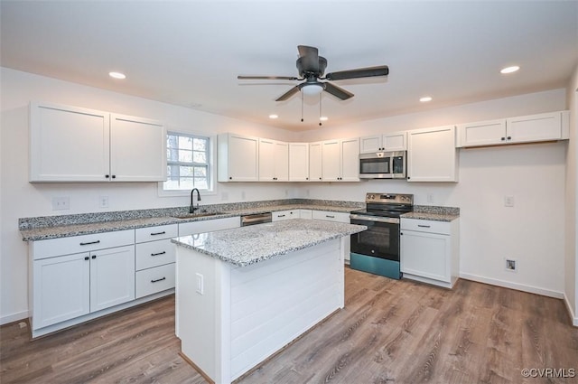 246 American Dr, Ruther Glen, VA 22546 - kitchen featuring appliances with stainless steel finishes, light stone countertops, a center island, a ceiling fan, and recessed lighting
