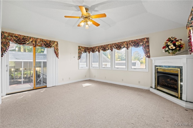 unfurnished living room with carpet floors, lofted ceiling, a wealth of natural light, and ceiling fan