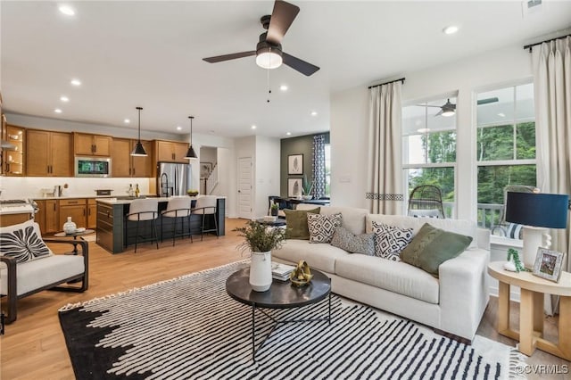 living room featuring ceiling fan and light hardwood / wood-style floors