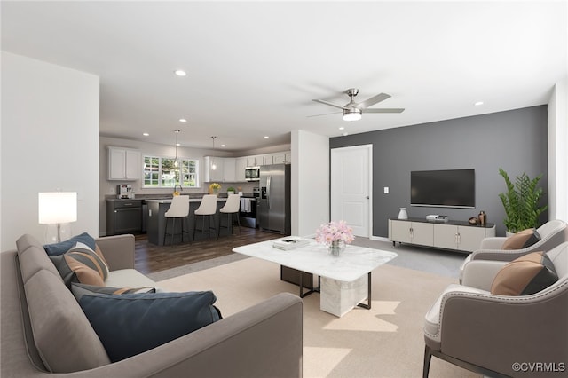 living room with ceiling fan and light hardwood / wood-style flooring