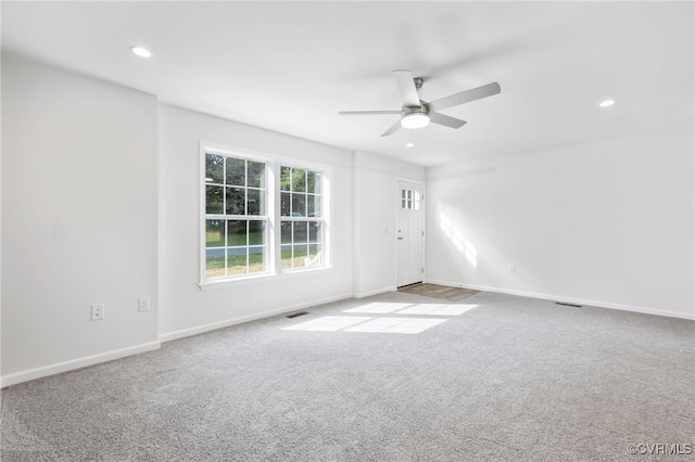 carpeted spare room with ceiling fan