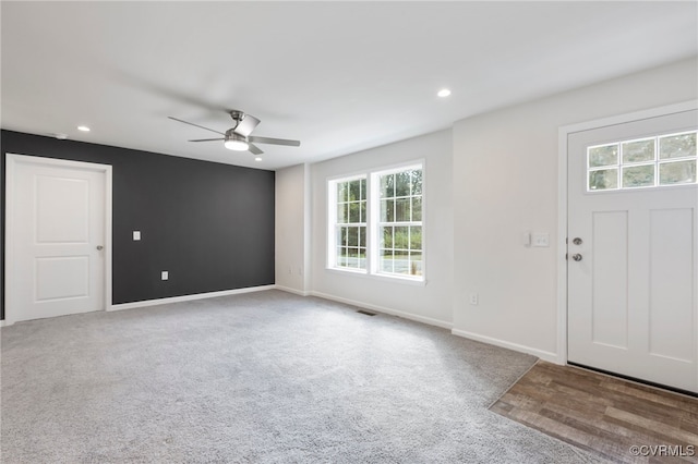 carpeted entrance foyer featuring ceiling fan