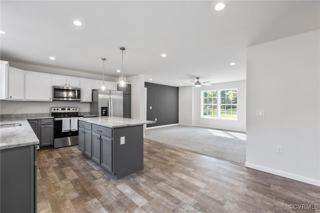 kitchen with gray cabinetry, white cabinetry, a kitchen island, stainless steel appliances, and decorative light fixtures