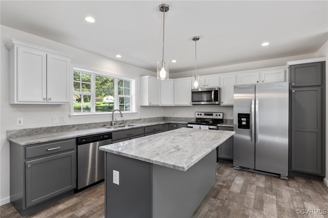 kitchen with pendant lighting, a center island, dark wood-type flooring, sink, and stainless steel appliances