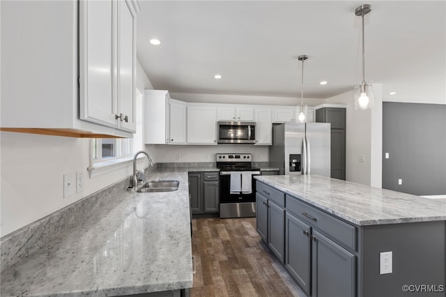 kitchen featuring white cabinets, pendant lighting, sink, stainless steel appliances, and a center island