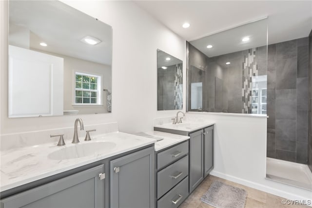 bathroom featuring vanity, tile patterned flooring, and a tile shower