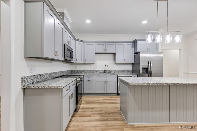 kitchen featuring light hardwood / wood-style floors, hanging light fixtures, stainless steel appliances, crown molding, and light stone countertops