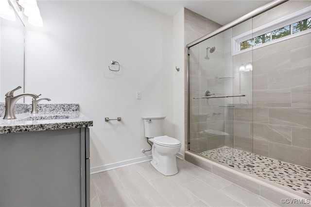 bathroom featuring an enclosed shower, vanity, and toilet