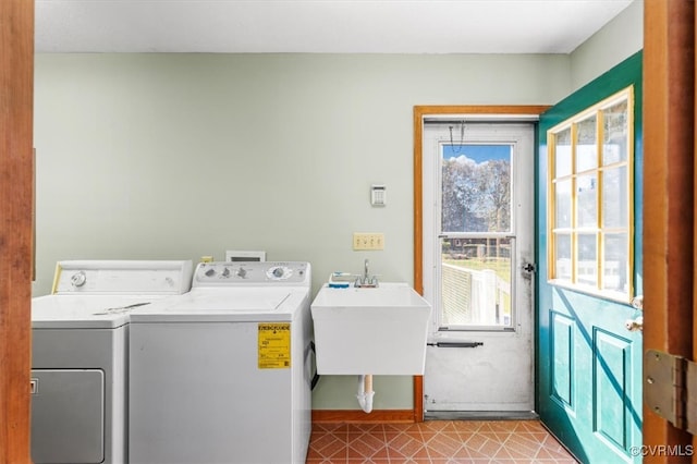 clothes washing area with sink, light tile patterned flooring, and independent washer and dryer