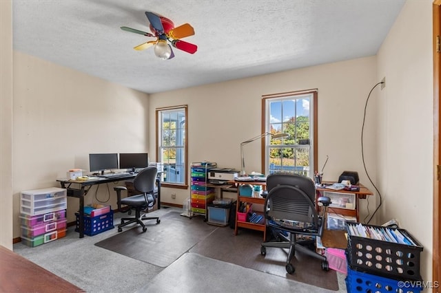 home office featuring a textured ceiling, carpet flooring, and ceiling fan