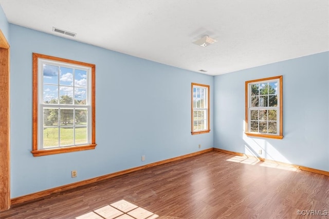 unfurnished room featuring hardwood / wood-style floors and plenty of natural light