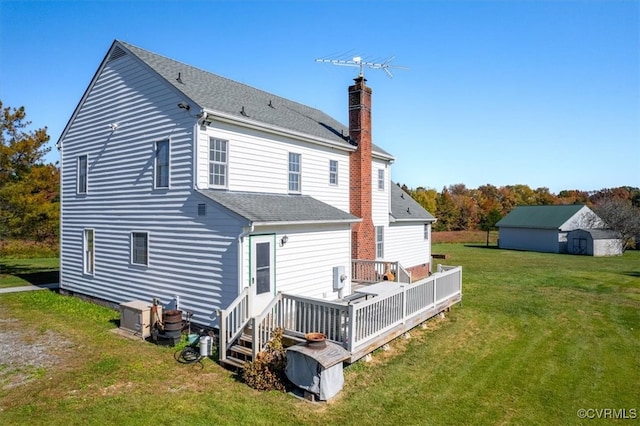 rear view of property featuring a yard, a storage shed, and a deck