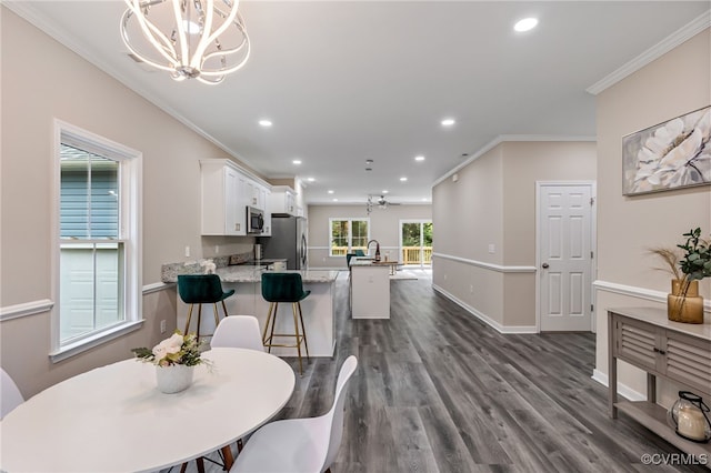 dining room with crown molding, a chandelier, and dark hardwood / wood-style floors