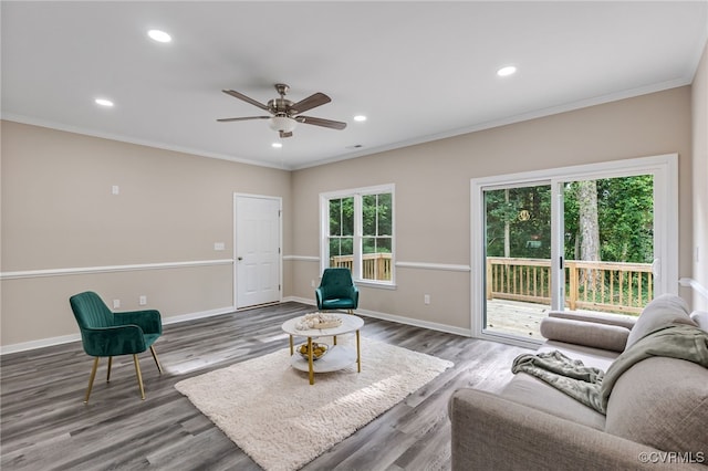 living room with ceiling fan, a wealth of natural light, ornamental molding, and wood-type flooring