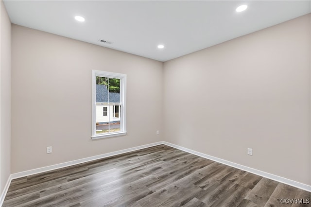 unfurnished room with dark wood-type flooring