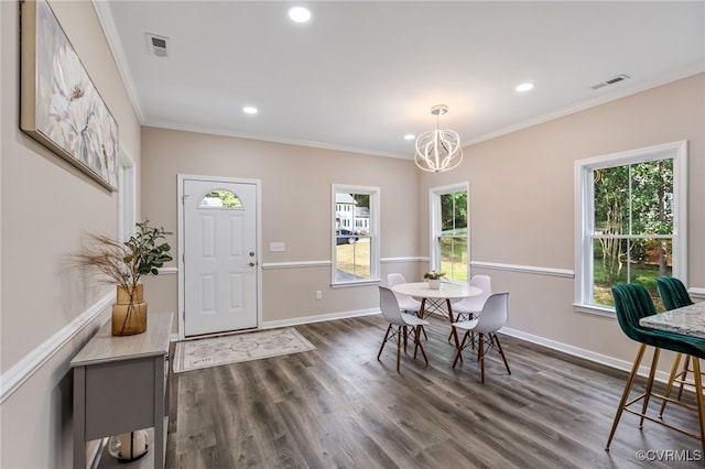 dining room with dark wood-type flooring, crown molding, and a chandelier