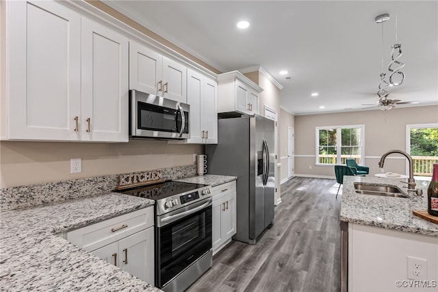 kitchen featuring pendant lighting, sink, stainless steel appliances, and white cabinets