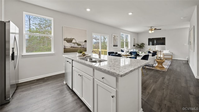 kitchen with white cabinetry, a healthy amount of sunlight, a center island with sink, and stainless steel appliances