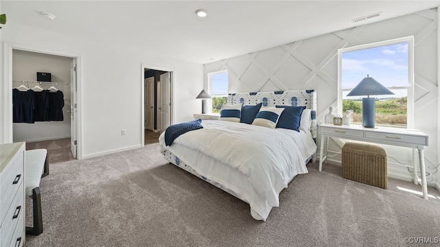 carpeted bedroom featuring a spacious closet and a closet