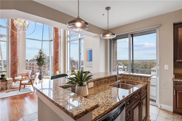 kitchen featuring sink, plenty of natural light, an island with sink, and light wood-type flooring