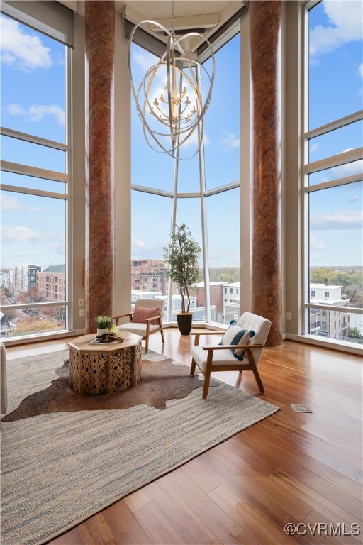 living area with hardwood / wood-style flooring, a healthy amount of sunlight, and a high ceiling