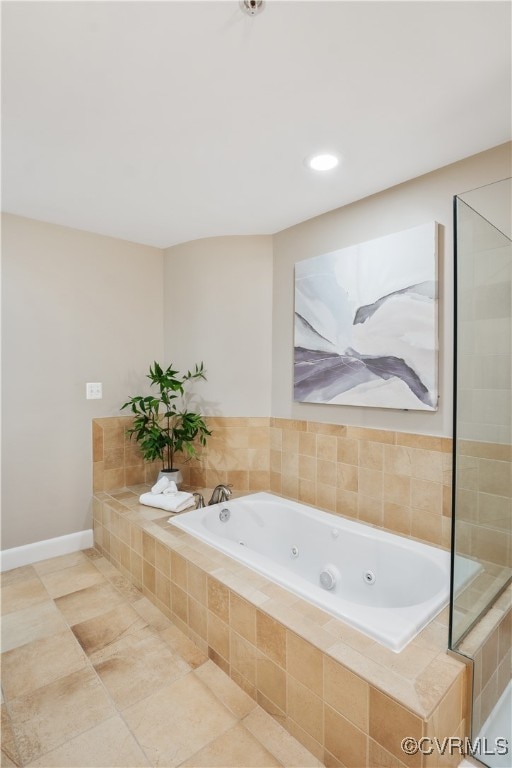 bathroom with tile patterned flooring and tiled bath