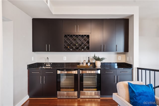 bar with dark stone countertops, sink, and wine cooler