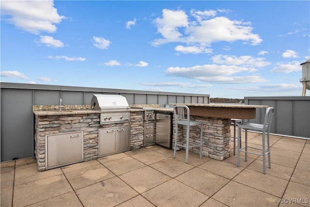 view of patio with area for grilling, exterior kitchen, and exterior bar