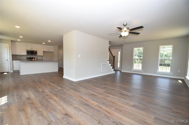 unfurnished living room featuring ceiling fan and hardwood / wood-style floors