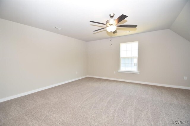 carpeted spare room with ceiling fan and vaulted ceiling