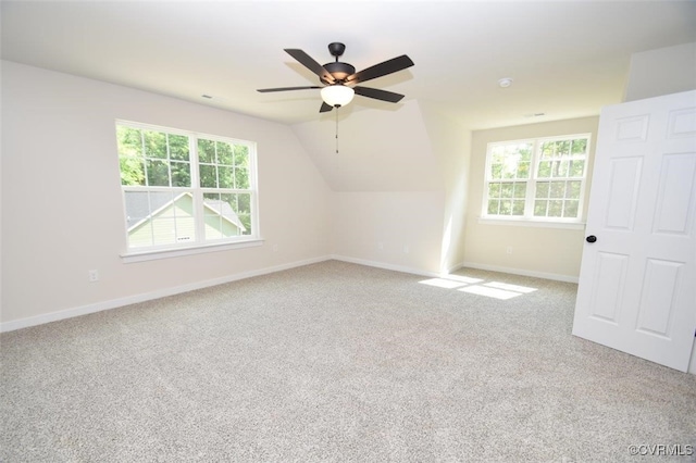 additional living space featuring carpet flooring, vaulted ceiling, ceiling fan, and plenty of natural light