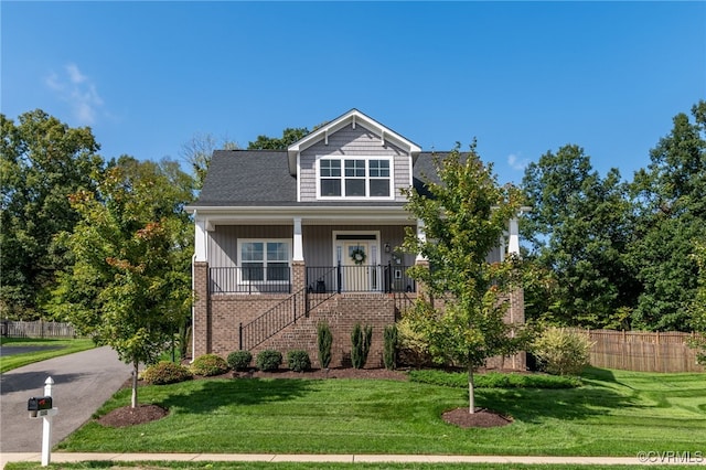 view of front facade with a front yard and covered porch