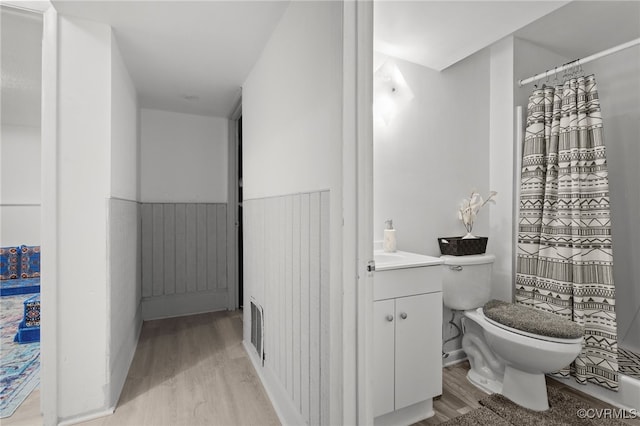 bathroom with hardwood / wood-style floors, vanity, and toilet