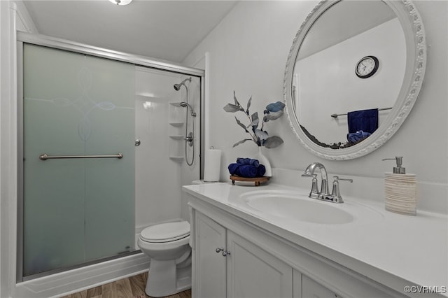 bathroom with hardwood / wood-style floors, vanity, toilet, and a shower with door