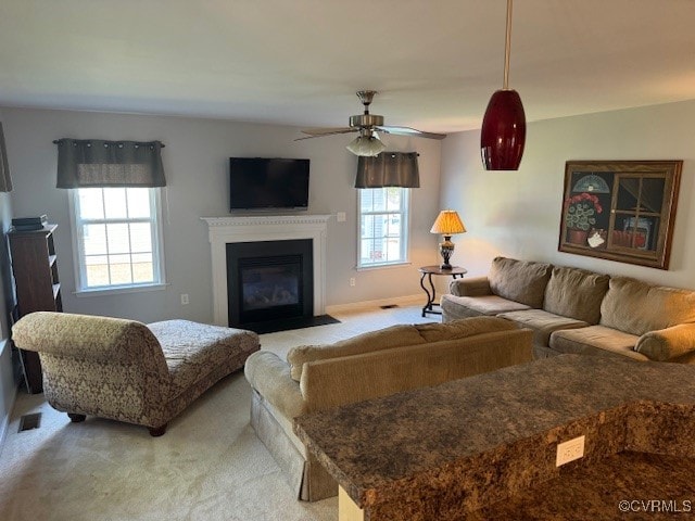 carpeted living room featuring ceiling fan and a healthy amount of sunlight