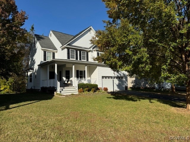 view of front of house featuring covered porch, a front yard, and a garage