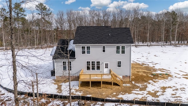 snow covered back of property featuring a wooden deck