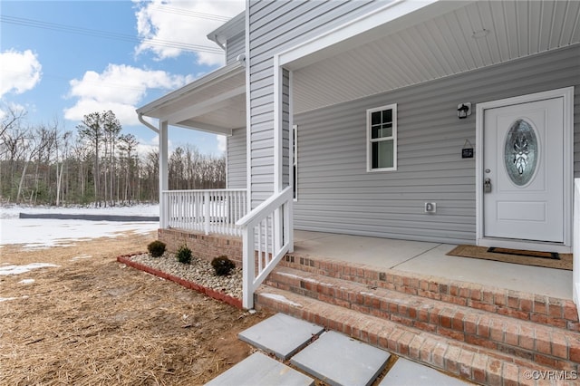 view of exterior entry featuring covered porch