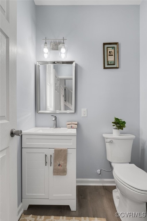 bathroom with hardwood / wood-style flooring, vanity, and toilet