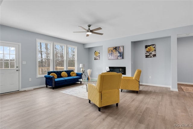 living room featuring ceiling fan, a healthy amount of sunlight, and light wood-type flooring