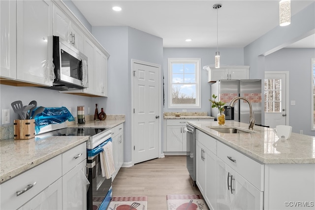 kitchen featuring pendant lighting, a center island with sink, white cabinets, sink, and stainless steel appliances