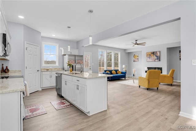 kitchen with white cabinets, stainless steel appliances, hanging light fixtures, and ceiling fan