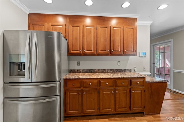 kitchen featuring light stone countertops, light hardwood / wood-style floors, crown molding, and stainless steel refrigerator with ice dispenser