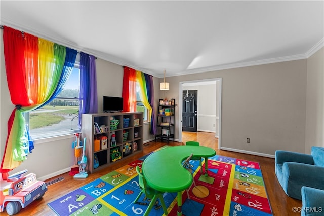 game room with hardwood / wood-style flooring and ornamental molding